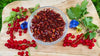 Video of dried red chili pepper rings in a glass bowl with fresh berries and herbs